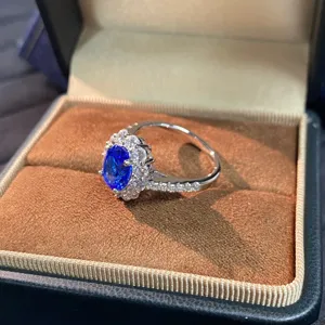 Silberner königsblauer Saphirring Detailaufnahme mit funkelndem Diamant-Halo-Design.