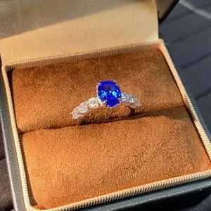 Vista di dettaglio del raffinato anello in argento con gemma blu nella custodia di velluto.