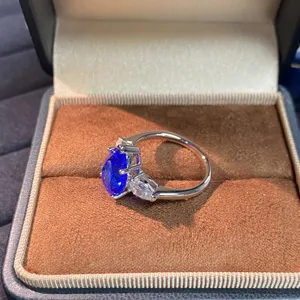 Primo piano dettagliato dell'anello in argento 925 con spinello blu e pietre laterali.