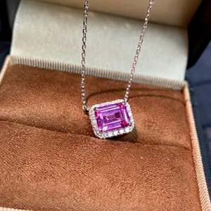 Primo piano di una collana con ciondolo in pietra rosa e cornice di luminosi zirconi.