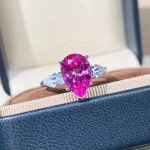 Detailopname van de prachtige peervormige roze saffierring met schitterende stenen eromheen.