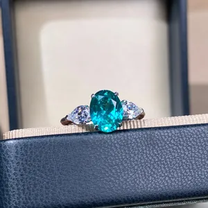 Primer plano detallado del anillo ovalado de topacio paraiba con piedras brillantes.