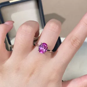 Close-up detail of stunning oval pink sapphire gemstone ring in sterling silver prong setting.