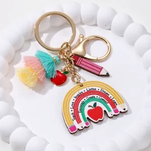 Detail van een leraar regenboog sleutelhanger met potlood en emaille appel bedeltjes