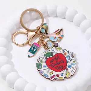 Cadeau sleutelhanger voor de dag van de leraar met appel en schoolspullen bedeltjes