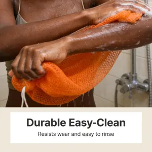 Primer plano de una red exfoliante naranja duradera usada en el brazo mojado bajo la ducha.