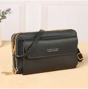 Detail view of a black multi-layer zippered women crossbody bag with adjustable shoulder strap.