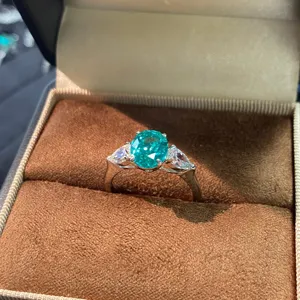 Hermoso anillo de plata 925 con topacio Paraiba ovalado y piedras laterales brillantes.