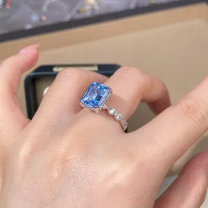 Stunning emerald-cut light blue aquamarine ring detail with sparkling side diamonds on hand.