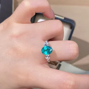 Detalle en primer plano del anillo de tres piedras de plata 925 con topacio paraiba.