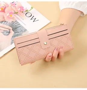 Pink quilted long wallet detail showing snap button, zipper pocket and multiple card slots.