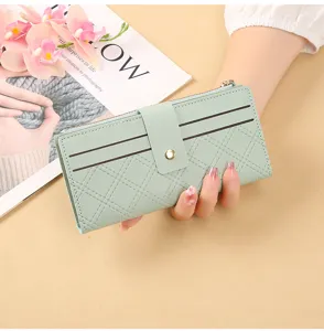 Detailed view of a light green quilted long wallet with multiple card slots and secure snap closure.