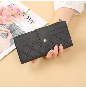 Black long wallet for women with snap button closure zipper and quilted card slots.