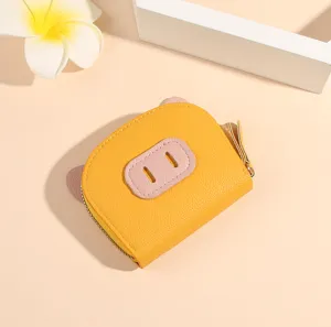 Gros plan détaillé du joli porte-monnaie design cochon jaune avec fermeture éclair sécurisée.