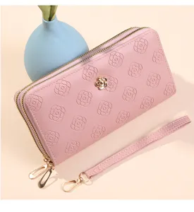 Portefeuille long femme rose avec double fermeture éclair, motif camélia et dragonne.
