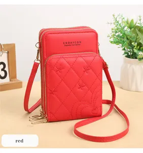 Vista dettagliata della borsa a tracolla mini trapuntata rossa con zip multiple e ricamo a cuore.