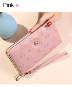 Portefeuille long rose pour femme avec double fermeture éclair et motif de fleurs gaufrées.