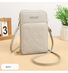 Borsa a tracolla grigia per cellulare con zip multiple, ricami floreali e design trapuntato.