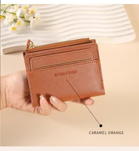 Close up view of the mini caramel orange card wallet showing multiple card slots and zipper pocket detail.