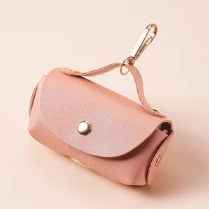 Tragbarer Hundebeutelhalter aus Leder mit Metallhaken in Rosa für den Gassigang im Freien.