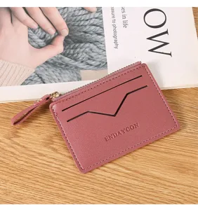 Detail shot of pink leather card holder zipper wallet with card slots and metallic zipper.