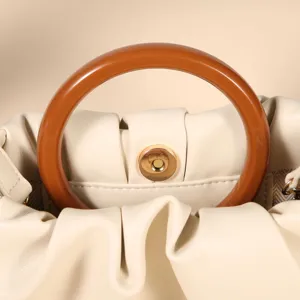 Elegante Handtasche aus Leder mit Raffungen, rundem Holzgriff und sicherem Druckknopfverschluss.