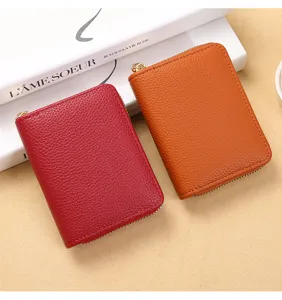 Gros plan de porte-cartes compacts à fermeture éclair en cuir grainé rouge et marron détail.