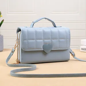 Gedetailleerd overzicht van de lichtblauwe gewatteerde crossbodytas met hartsluiting en ritsen.