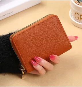Détail de porte-cartes accordéon en cuir marron, avec fentes multiples et fermeture éclair.