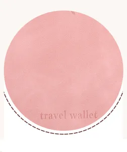 Close-up detail of pink travel wallet PU leather surface showing soft texture and embossed text.