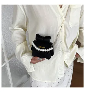 Gros plan détail du sac à main élégant pour femmes avec chaîne de perles et nœud chic.