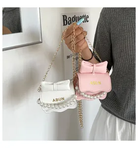 Vue détaillée du mini sac à épaule tendance pour femme avec perles, nœud et chaîne.