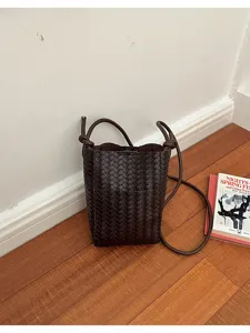 Dark brown woven leather phone bag detail, chic crossbody mini bag for women daily.