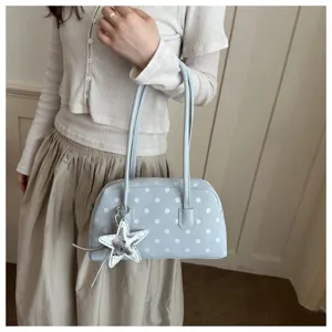 Detailed view of the light blue polka dot shoulder pillow bag with a shiny silver star pendant.