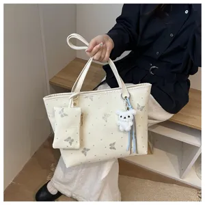 Chic white butterfly tote bag for women, stylish commuter shoulder bag with cute plush charm.