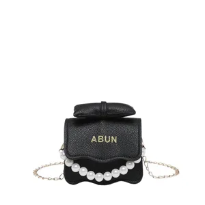 Élégant petit sac bandoulière noir pour femme avec poignée perle et chaîne dorée.