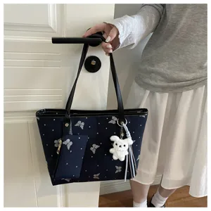 Detailed view of the dark blue tote bag with butterfly patterns and cute bunny charm.
