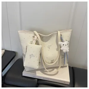 Detailed view of the commuting tote bag with butterfly patterns and cute plush bunny charm.
