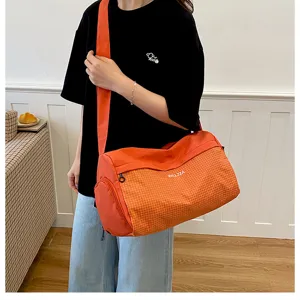 Large capacity orange checkered travel duffel bag, casual shoulder gym bag for women.