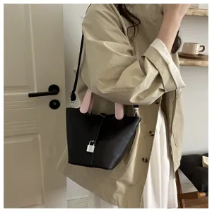 Stylish black leather bucket bag with pink top handles and silver padlock detail for women.