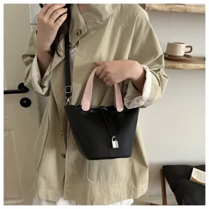 Chic black bucket bag with pink handles and silver lock, stylish leather shoulder bag for women.