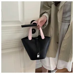 Stylish black bucket bag with pink handles detail, perfect for daily casual wear outfit.