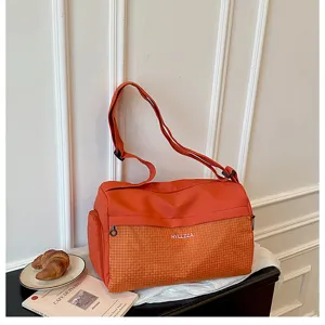 Orange travel duffel bag detail, large capacity gym bag with grid pocket and strap.