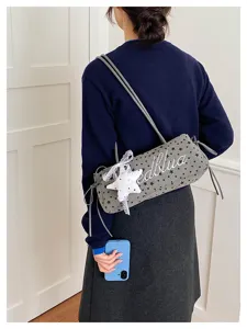 Borsa a spalla cilindrica grigia con stampa stelle e ciondolo in pizzo, stile di nicchia chic.
