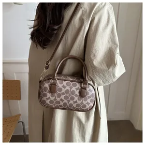 Detail view of the vintage brown monogram bowling bag with shoulder strap and top handles.