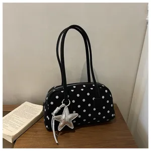 Detail view of black white polka dot underarm shoulder bag with cute silver star charm pendant.