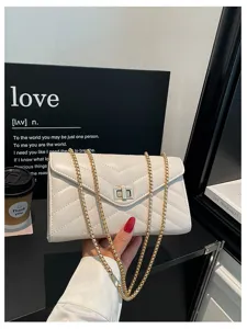 Weiß gesteppte Umhängetasche Detailansicht, elegantes Zickzack-Muster mit goldener Hardware.