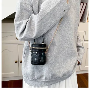 Stylish mini black bucket bag with gold chain strap and cute pattern design for chic girls.