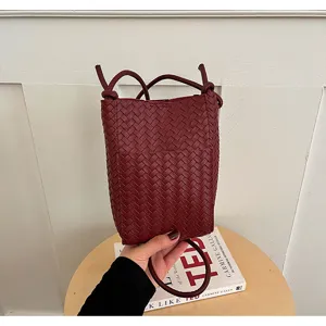 Woven leather phone bag detail, dark red PU crossbody mini bag with shoulder strap design.