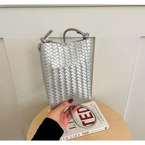 Detailed view of stylish silver woven mobile phone bag, trendy women crossbody bag.